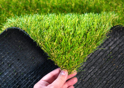 Hand,holding,an,artificial,grass,roll.,greenering,with,an,artificial