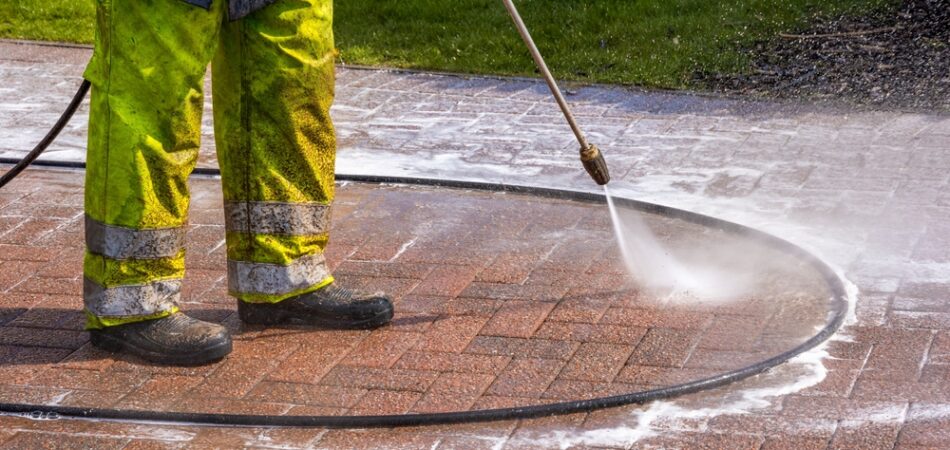 Worker,in,yellow,protective,clothing,pressure,washing,monoblock,brick,paver